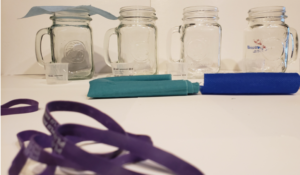 Photo of supplies used in the DIY mask test of water resistance including elastics, fabrics, and glass jars