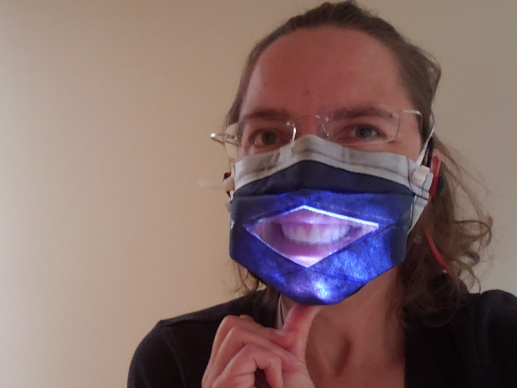 Photo of Dr. Songer in the MakerMask: Expression Glow Prototype: a window mask made with heat sealed seams and an internal light to improve visibility of the mouth in dimly lit situations.