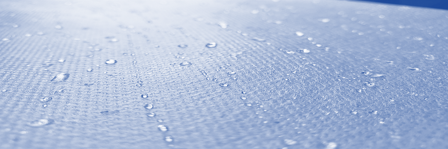 Photo: blue nonwoven polypropylene with water droplets beaded up on it.