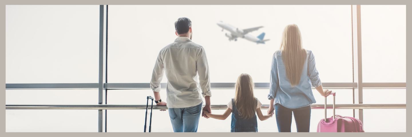 Picture of Parents with their Kid at an airport watching an airplane fly